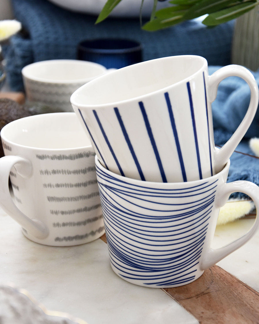 Blue and white striped ceramic wide mug with nautical design, sturdy handle, on a light wooden table background.