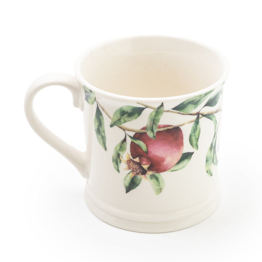 Sturdy tankard mug with a vivid illustration of a pomegranate tree, featuring deep red pomegranate fruits set against lush green leaves, all on a glossy white background.